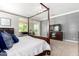 Primary bedroom featuring a four-poster bed, neutral color palette, and a view into the living room at 2892 E Fruitvale Ave, Gilbert, AZ 85297