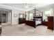Large primary bedroom with a four-poster bed, dual nightstands, dresser, and neutral carpeting at 2892 E Fruitvale Ave, Gilbert, AZ 85297