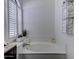 Elegant soaking tub with white shutters, a plant, and bath towels, creating a spa-like retreat at 2940 E Norwood St, Mesa, AZ 85213