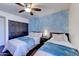 Comfortable bedroom featuring two beds, a ceiling fan, and a stylish blue accent wall at 2940 E Norwood St, Mesa, AZ 85213
