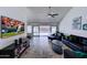 Open concept living room featuring neutral tile flooring, ceiling fan, and sliding glass doors at 2940 E Norwood St, Mesa, AZ 85213