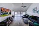 Open concept living room featuring neutral tile flooring, ceiling fan, and sliding glass doors at 2940 E Norwood St, Mesa, AZ 85213