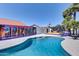 Inviting pool area with custom mural, basketball court, lush palm trees, and lounging areas; perfect for entertaining at 2940 E Norwood St, Mesa, AZ 85213