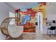 The sitting area has a unique chair near an artistic mural, leading to the kitchen and other areas of the home at 2940 E Norwood St, Mesa, AZ 85213