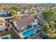 An aerial view of a house with a blue swimming pool, well-kept yard and lush greenery, surrounded by other homes at 3058 E Nance St, Mesa, AZ 85213