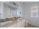 Bright bathroom featuring double sinks, granite countertops, and an arched window at 3058 E Nance St, Mesa, AZ 85213