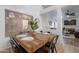 Modern dining area with a rustic wooden table and views into the living room, creating an open concept at 3058 E Nance St, Mesa, AZ 85213