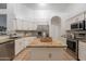 Updated kitchen boasts stainless steel appliances, granite counters, white cabinets, and a kitchen island at 3058 E Nance St, Mesa, AZ 85213