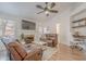 Relaxing living room boasts a fireplace, leather furniture, ceiling fan, and built-in shelving for work or study at 3058 E Nance St, Mesa, AZ 85213