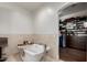 Luxurious bathroom featuring a soaking tub and a spacious walk-in closet with custom shelving at 320 N Portland Ave, Gilbert, AZ 85234