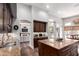 Modern kitchen featuring dark cabinets, granite countertops, and a view of the cozy living room at 320 N Portland Ave, Gilbert, AZ 85234