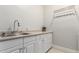 Clean laundry room with white cabinets, sink, and plenty of counter space at 320 N Portland Ave, Gilbert, AZ 85234