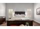 Well-lit bedroom featuring a comfortable bed with decorative pillows and shutters on the windows at 320 N Portland Ave, Gilbert, AZ 85234
