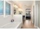 Bright bathroom features a white soaking tub, tile floors, and shuttered windows at 3476 E Orchid Ln, Gilbert, AZ 85296