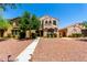 Charming two-story home with a desert landscape and walkway to the front door at 3476 E Orchid Ln, Gilbert, AZ 85296