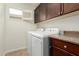 A laundry room features a washer and dryer, built-in cabinets, a countertop, and a window for natural light at 3476 E Orchid Ln, Gilbert, AZ 85296