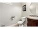 Cozy powder room featuring a granite vanity and decorative mirror at 3476 E Orchid Ln, Gilbert, AZ 85296