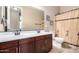 A bathroom with double sinks, a large mirror, and a shower with decorative curtain at 35654 N Vidlak Dr, San Tan Valley, AZ 85143