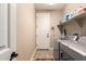 A functional laundry room with modern washer and dryer, shelving, and convenient access to the door at 35654 N Vidlak Dr, San Tan Valley, AZ 85143