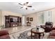 Cozy living room with a ceiling fan, a large entertainment center, and a sliding glass door at 35654 N Vidlak Dr, San Tan Valley, AZ 85143