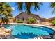 Inviting pool with beautiful landscaping, set in a well-maintained backyard oasis with mature palms at 35654 N Vidlak Dr, San Tan Valley, AZ 85143