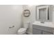 Half bathroom featuring a gray vanity with decorative mirror and toilet at 3805 E Desert Flower Ln, Phoenix, AZ 85044