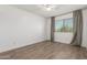 Bright bedroom featuring wood-look tile flooring and a window that invites natural light and warmth at 3805 E Desert Flower Ln, Phoenix, AZ 85044
