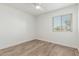 Inviting bedroom featuring wood-look tile flooring and a window, creating a serene and airy atmosphere at 3805 E Desert Flower Ln, Phoenix, AZ 85044