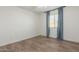 Cozy bedroom featuring wood-look tile floors and a window with blue curtains for a comfortable retreat at 3805 E Desert Flower Ln, Phoenix, AZ 85044