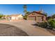 Beautiful home featuring a wide driveway, lush landscaping, and a convenient three-car garage at 3805 E Desert Flower Ln, Phoenix, AZ 85044