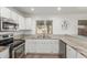 Well-lit kitchen featuring stainless steel appliances and white cabinetry at 3805 E Desert Flower Ln, Phoenix, AZ 85044