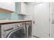 Modern laundry room with a washer and dryer, ample counter space, and cabinets for organized efficiency at 3805 E Desert Flower Ln, Phoenix, AZ 85044