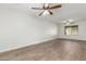 Spacious living room with wood-look flooring, modern ceiling fan, and bright natural light at 3805 E Desert Flower Ln, Phoenix, AZ 85044