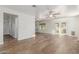 Open-concept living space with wood-look floors, ceiling fan, access to kitchen and backyard at 3805 E Desert Flower Ln, Phoenix, AZ 85044