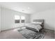 Bright bedroom with neutral carpeting, a modern gray bed frame, and large windows offering ample natural light at 38099 N Stallion St, San Tan Valley, AZ 85140