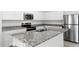 Modern kitchen featuring stainless steel appliances, granite countertops, and sleek white cabinetry at 38099 N Stallion St, San Tan Valley, AZ 85140