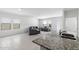 Bright living room featuring neutral tile flooring, modern gray furniture, and plenty of natural light from large windows at 38099 N Stallion St, San Tan Valley, AZ 85140