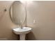 Small half-bathroom features a pedestal sink and oval mirror, ideal for guests and added convenience at 3932 S Crosscreek Dr, Chandler, AZ 85286