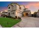 Two-story home showcasing a well-manicured lawn, neutral paint, and a two car garage with driveway under a colorful sky at 3932 S Crosscreek Dr, Chandler, AZ 85286