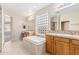 Bright bathroom with soaking tub, vanities, and a tiled shower with glass block window for privacy at 4336 W Hackamore Dr, Phoenix, AZ 85083