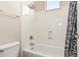 Bathroom with a shower and bathtub combination, gray shower curtain, and tile walls at 4336 W Hackamore Dr, Phoenix, AZ 85083