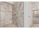 Tiled shower stall with shower head, built-in shelf, and tile flooring in a well-lit bathroom at 4336 W Hackamore Dr, Phoenix, AZ 85083