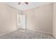 Neutral carpeted bedroom with ceiling fan and open door that shows the neutral color palette of the home at 4336 W Hackamore Dr, Phoenix, AZ 85083