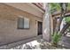 Condo front door with security gate and window beside it, and xeriscaping underneath tree at 4354 N 82Nd St # 167, Scottsdale, AZ 85251