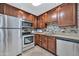 Updated kitchen featuring stainless steel appliances, granite countertops, and dark wood cabinetry with mosaic tile backsplash at 4354 N 82Nd St # 167, Scottsdale, AZ 85251