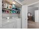 A laundry room with side-by-side machines and shelving is adjacent to a bedroom at 441 S Maple -- # 83, Mesa, AZ 85206