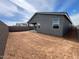 Exterior view of home and backyard with dirt, block wall, and covered patio at 47451 W Kenner Dr, Maricopa, AZ 85139