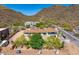 Aerial view showcases mature trees, landscaping, and desert terrain against a mountain backdrop at 5801 E Surrey Dr, Cave Creek, AZ 85331