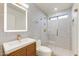 Modern bathroom featuring stylish wood vanity, a lighted mirror, and a sleek glass-enclosed shower at 5801 E Surrey Dr, Cave Creek, AZ 85331
