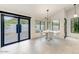 Bright dining area featuring white brick walls, a modern light fixture, and a glass door to an outdoor patio at 5801 E Surrey Dr, Cave Creek, AZ 85331